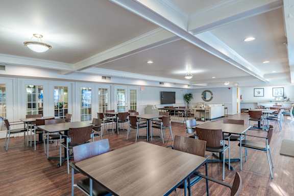 A large room with tables and chairs and a TV at Kendrick Court, Herndon, 20171