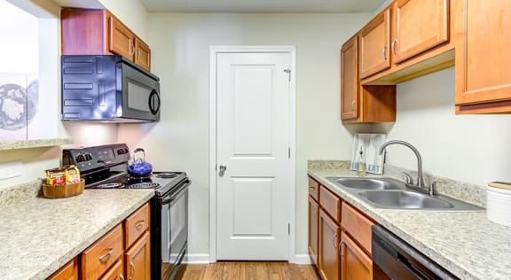 a kitchen with wood cabinets and granite countertops  at The Bristol Apartments, Greenville, 29601
