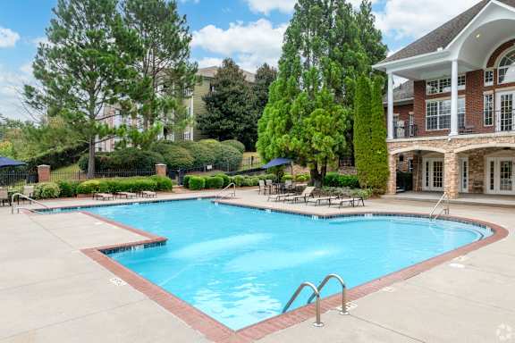 a large swimming pool in front of a building with a resort style pool at Magnolia Lake Apartments, Georgia 30117