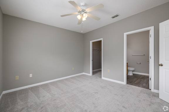 an empty living room with a ceiling fan and a door to a bathroom at Magnolia Lake Apartments, Georgia 30117