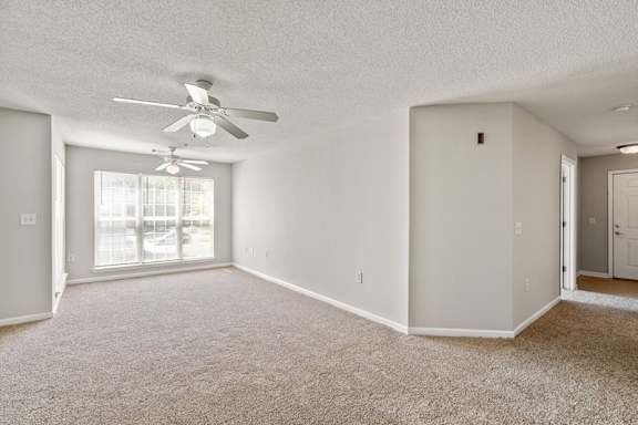 A room with a ceiling fan and carpeted floor at Palms on Ashley River Apartments, Ladson