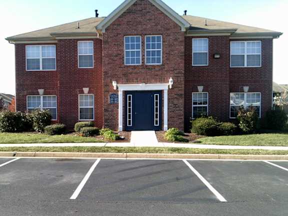 A red brick building with a black door and windows at The Regency Apartment Homes, Manassas, VA