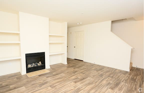 A room with a fireplace and wooden floors at The Regency Apartment Homes, Manassas, VA