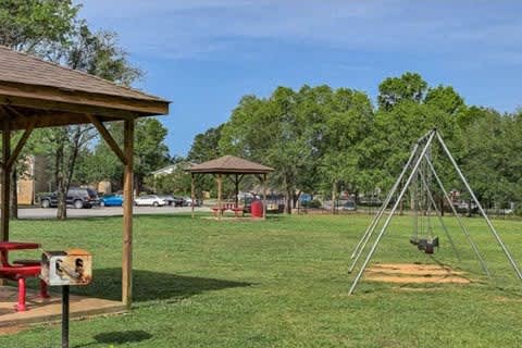 A playground with a swing set and picnic table at Gates at Summerville, Summerville, SC, South Carolina