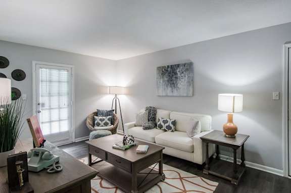 A living room with a white couch, a coffee table, and a lamp at Gates at Summerville, Summerville, SC, South Carolina