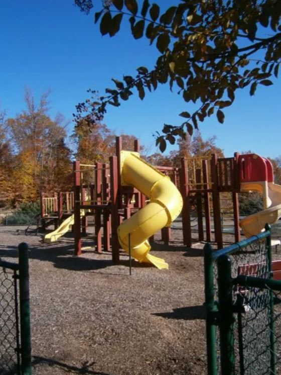 A playground with a yellow slide and a red slide at The Village at England Run, Fredericksburg, VA