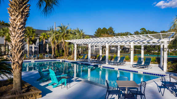 a resort style pool with lounge chairs and a pergola at Dwell at Greenridge, North Charleston, SC, 29406