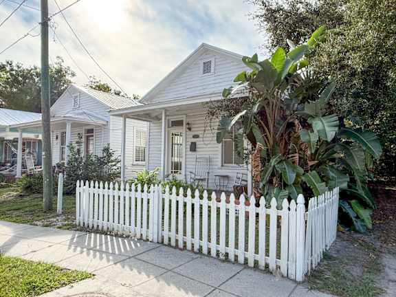 A white picket fence in front of a house.