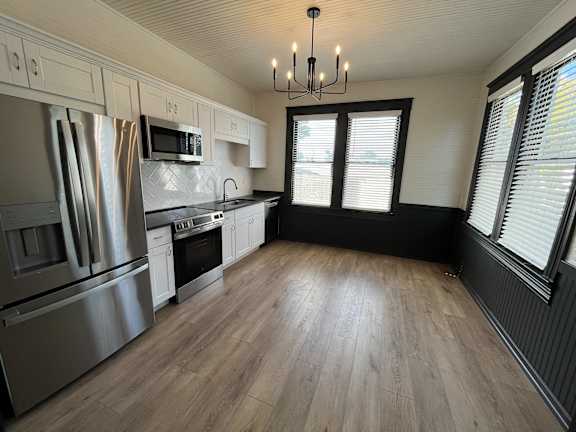 A kitchen with wooden floors and stainless steel appliances.