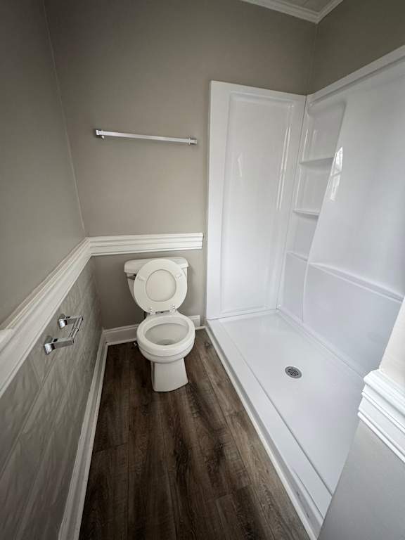 A bathroom with a toilet and a wooden wall.