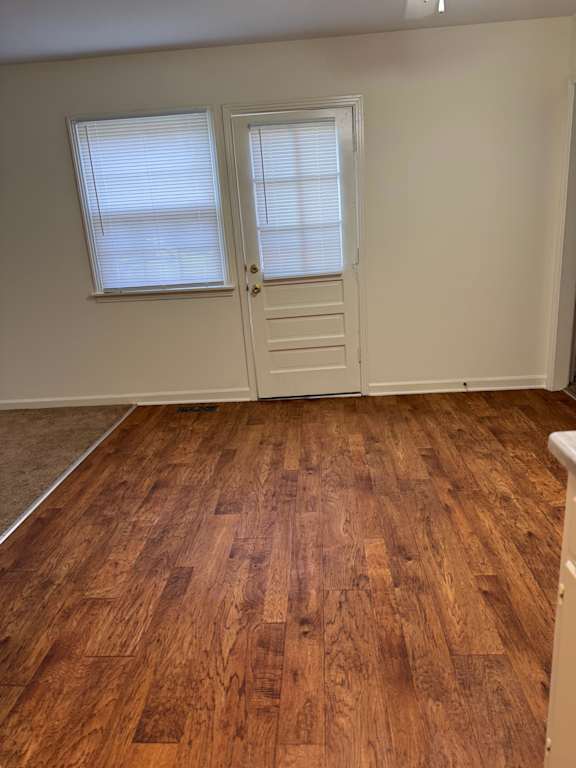 A room with wooden flooring and a white door.