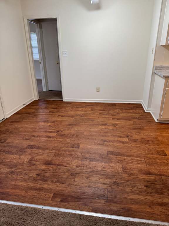 A room with wooden flooring and a white wall.