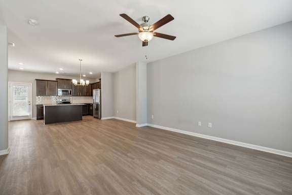 A spacious room with a ceiling fan and lighting fixtures.