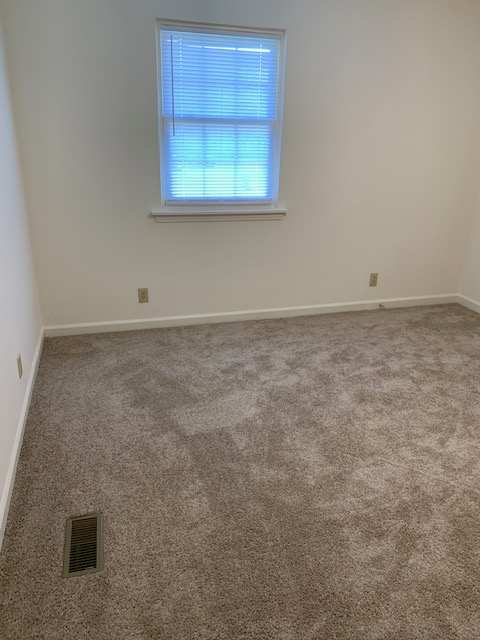 a window in a room with a wall and a vent