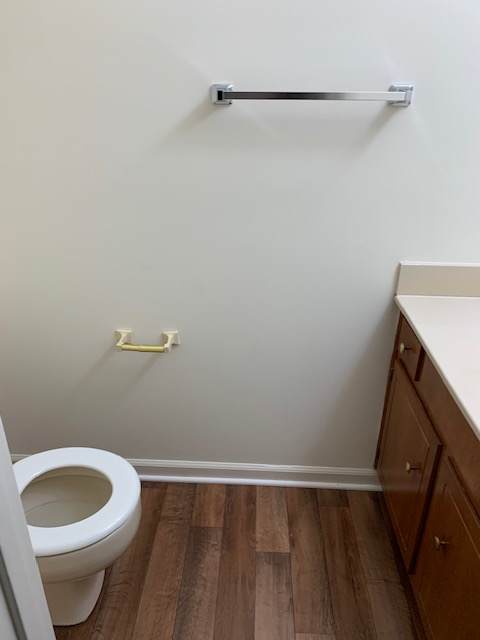 a white toilet in a bathroom with a white wall