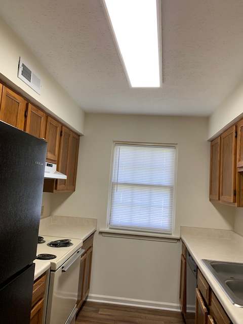 a kitchen with a black counter top and a window