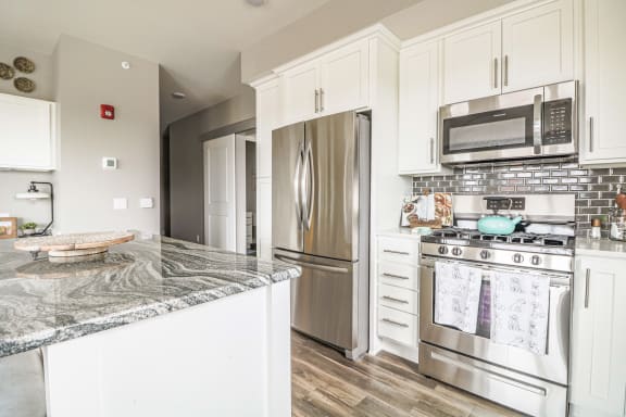 a kitchen with stainless steel appliances and white cabinets at Vue at Bluestone, Duluth, Minnesota