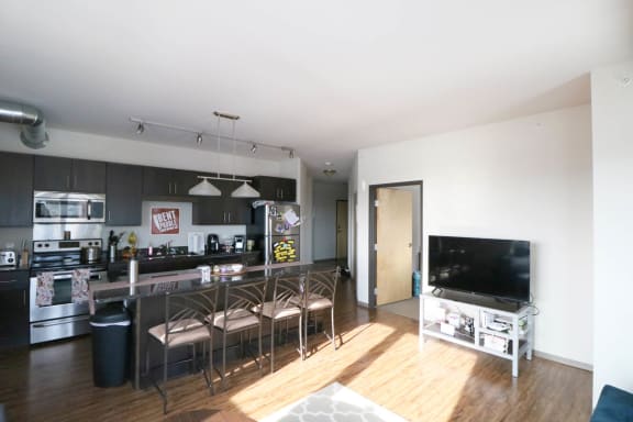 a kitchen and living room with a bar and a television at Bluestone Lofts, Duluth Minnesota
