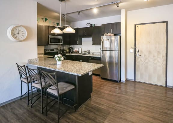 a kitchen with a marble counter top and a stainless steel refrigerator at Bluestone Lofts, Duluth, 55803