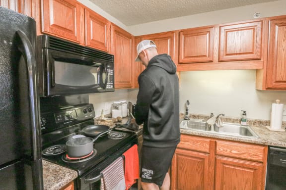 a man standing in a kitchen preparing food on the stove at Summit Ridge, Duluth, Minnesota