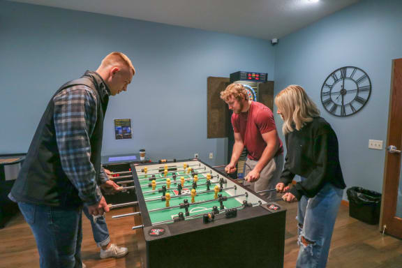 three people playing a game of foosball on a table at Summit Ridge, Duluth, Minnesota
