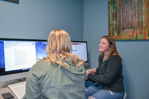 two women sitting at a desk in front of a computer at Summit Ridge, Duluth, Minnesota