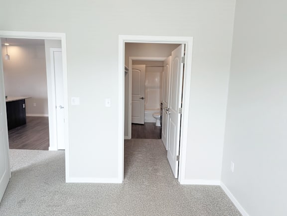 A white hallway with two open doors leading to other rooms.