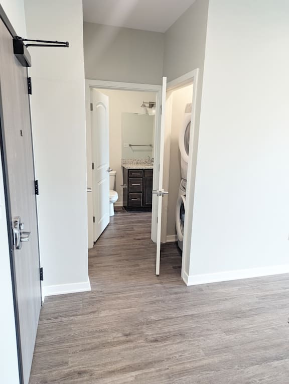 A hallway with a washing machine in the doorway.