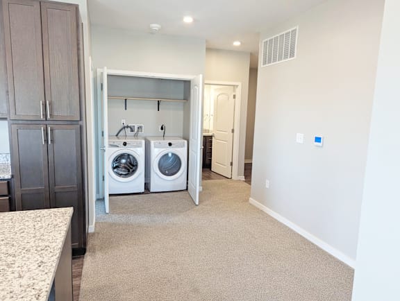 Laundry closet with stacked washer and dryer inside the apartment at Heartland Flats North Platte.