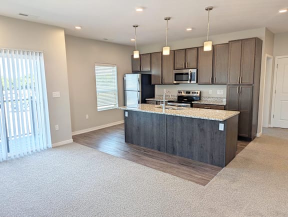 Kitchen with center island, cabinetry, stainless steel appliances and pendant lighting at Heartland Flats North Platte.