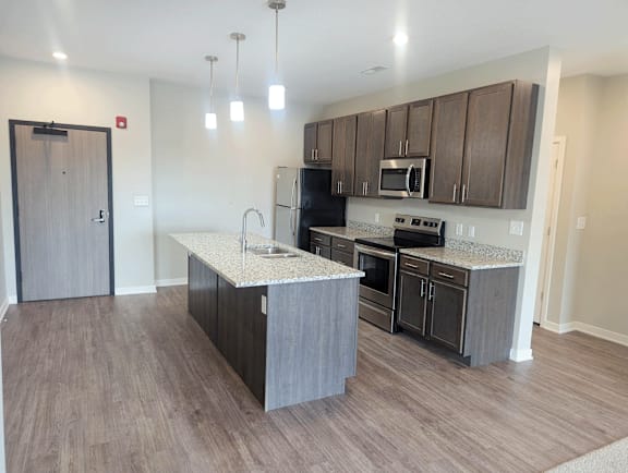 A kitchen with a sink, stove, and oven.
