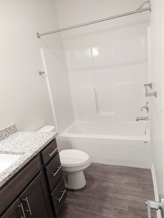 A white toilet sits in a bathroom next to a walk-in shower.