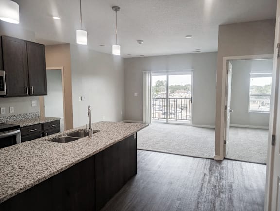 A kitchen with granite countertops and dark wood cabinets.