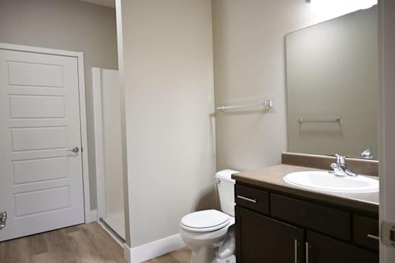 A white toilet sits in a bathroom next to a white door.