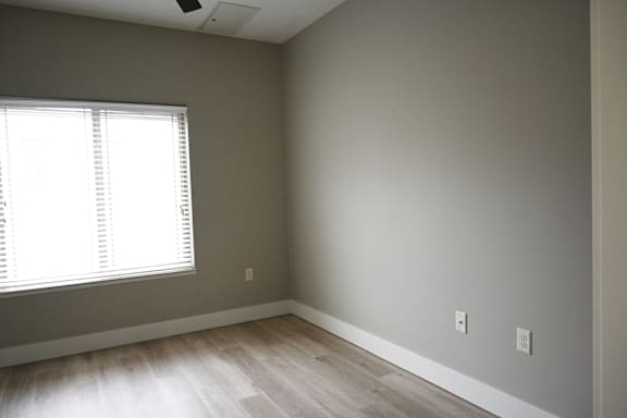 A room with a window and wooden flooring.