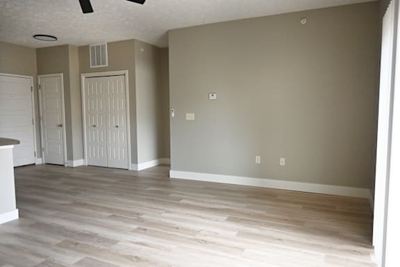 A room with a white door and a ceiling fan.