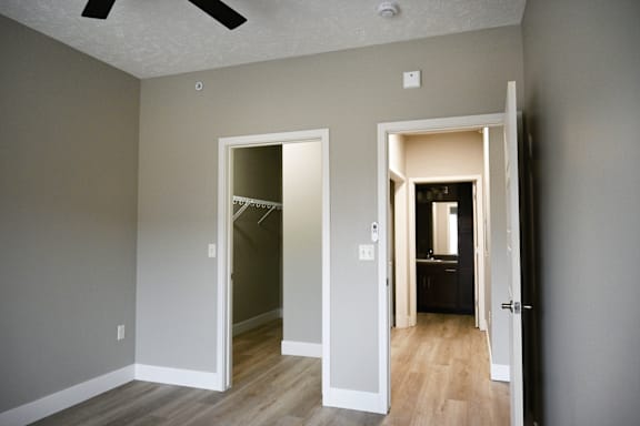 A room with two open doors and a ceiling fan.
