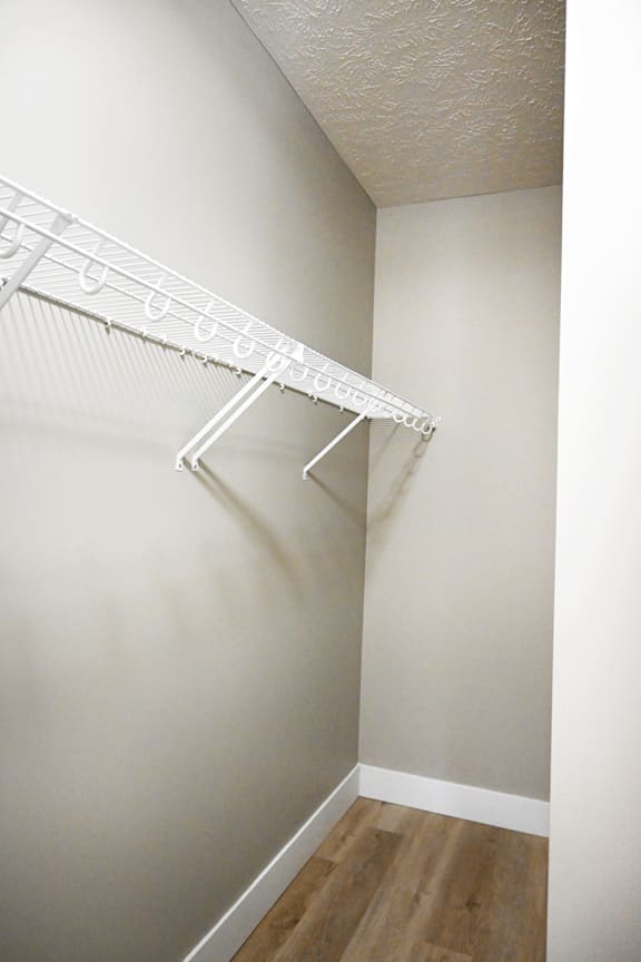 A white clothes hanger is on a white wall.