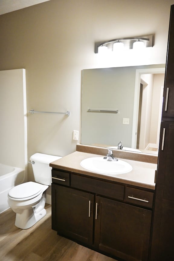 A white toilet sits next to a sink in a bathroom.