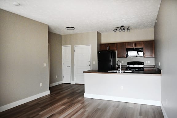 A kitchen with a black fridge and white cabinets.
