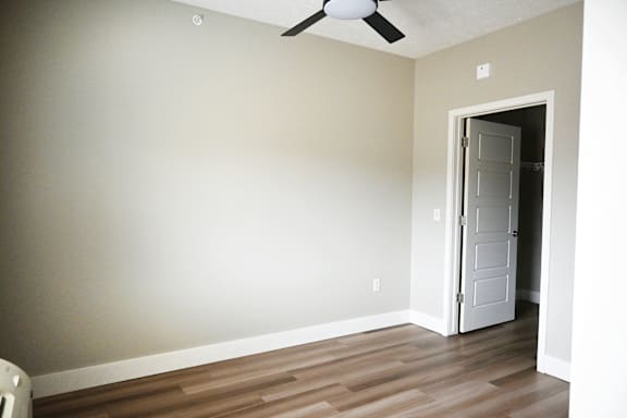 A room with a ceiling fan and a door.