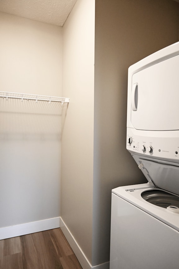A white dryer is sitting next to a white wall.
