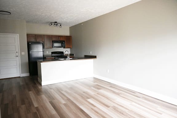 A kitchen with a white island and wooden floors.