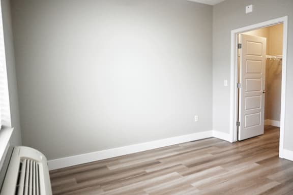 A room with a white door and a radiator on the floor.