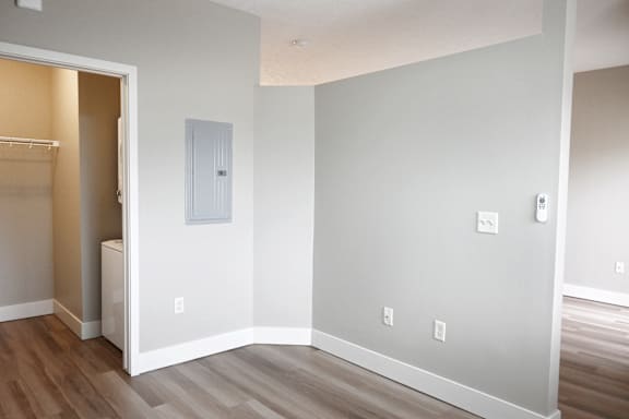 A room with a white door and a white wall with a switch.