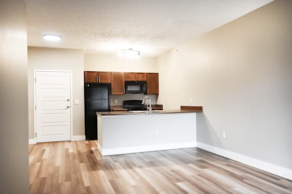 A kitchen with wooden floors and white walls.