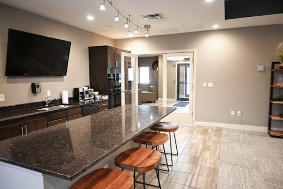 A kitchen with granite countertops and bar stools.