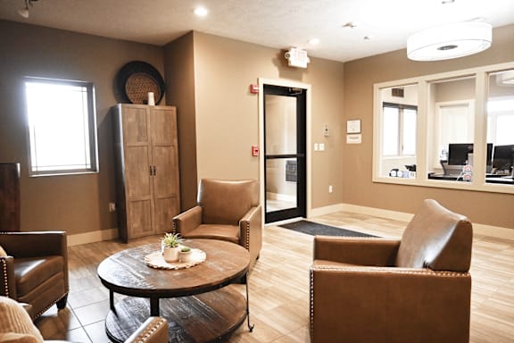 A living room with brown leather chairs and a wooden coffee table.