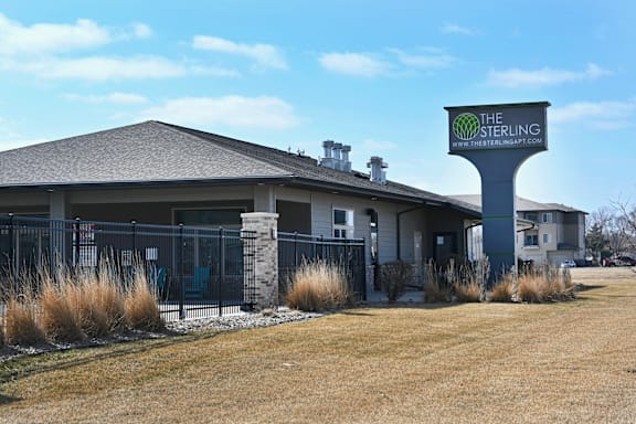 The Sterling apartments are located in a grassy area with a clear blue sky.