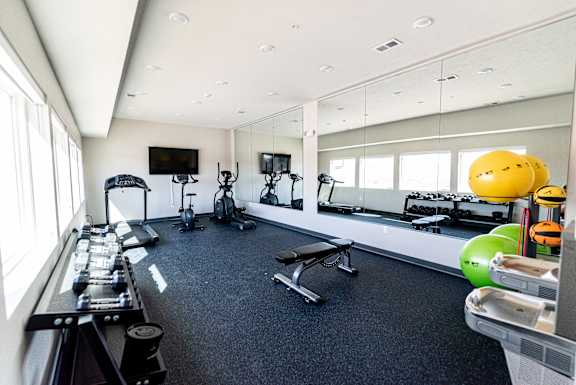 Fitness center with exercise machines, free weights and open workout area at Heartland Flats Alliance.